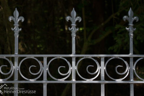 Gartenzaun aus Metall mit Schmiedeverzierungen
