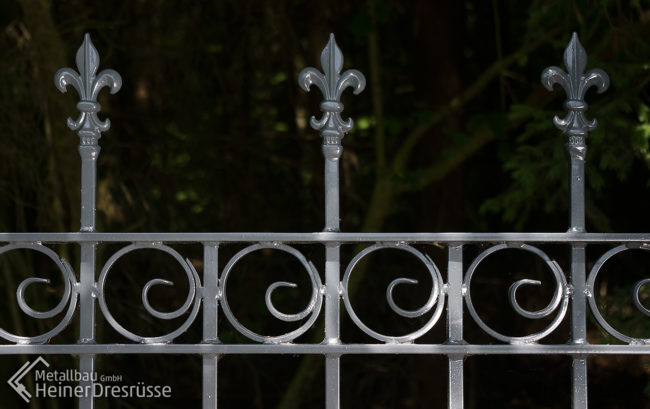 Gartenzaun aus Metall mit Schmiedeverzierungen