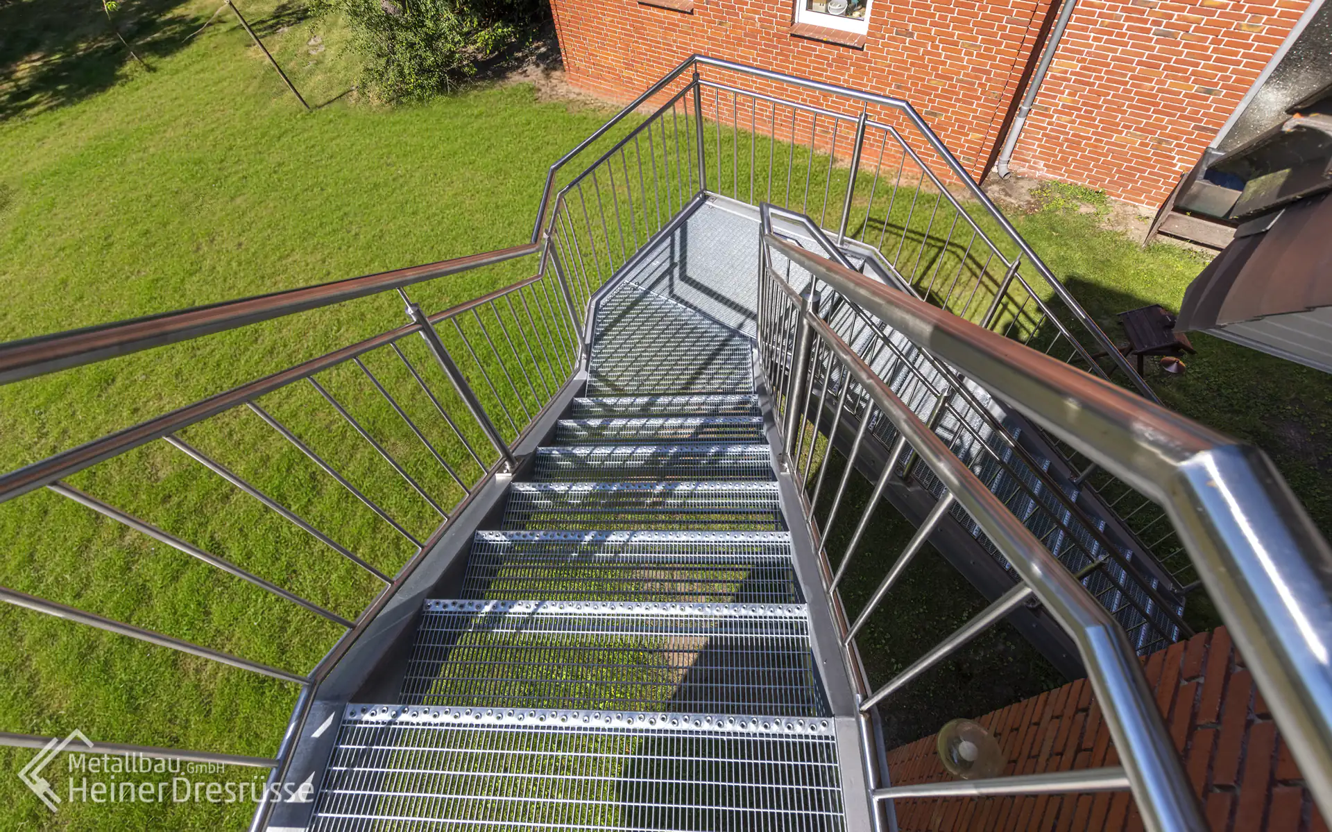 Metalltreppe in den Garten mit Edelstahlgeländer und Trittstufen aus feinmaschigem Gitterrost